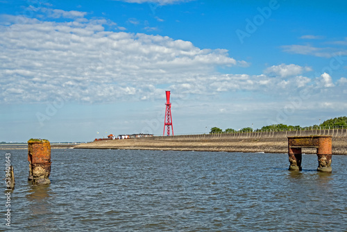 Eckwarderhörne an der niedersächsischen Nordseeküste mit Leuchtturm Oberfeuer Preußeneck und Resten eines alten Schiffsanlegers, Deutschland photo