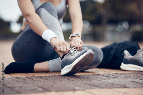 Fitness, runner and woman with shoe lace in sports motivation for workout, exercise or training in the outdoors. Female tying shoes for a run in healthy sport for cardio exercising in a urban town