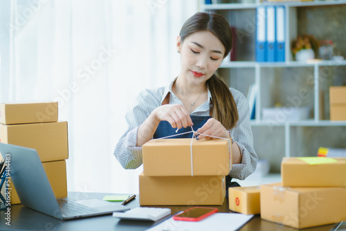 Asian teenager owner business woman work at home for online shopping and sale. © Kritdanai