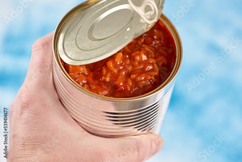 Open iron can in men's hand.