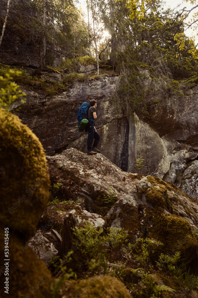 A caucasian man hiking in the forest standing on a rock. A caucasian man hiking in the forest standing on a rock.