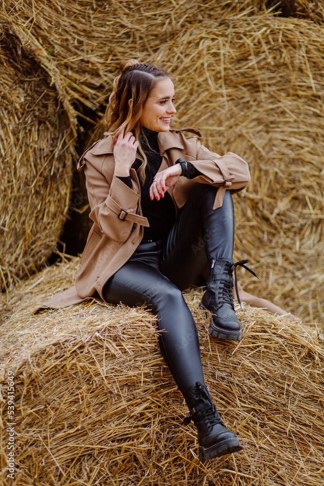 Cute smiling girl with hat posing in front of wheat straw bale Cute smiling girl with hat posing in front of wheat straw bale