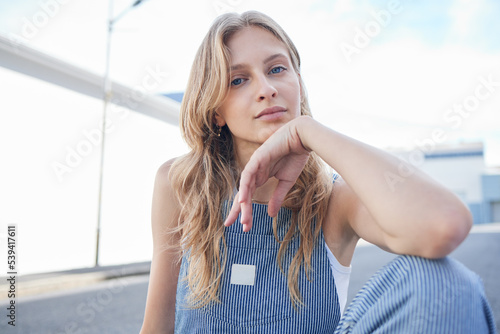 Fashion, beauty and city with a model woman outdoor on the road or street for contemporary and edgy style. Portrait, trendy and clothes with an attractive or stylish young female in an urban town photo