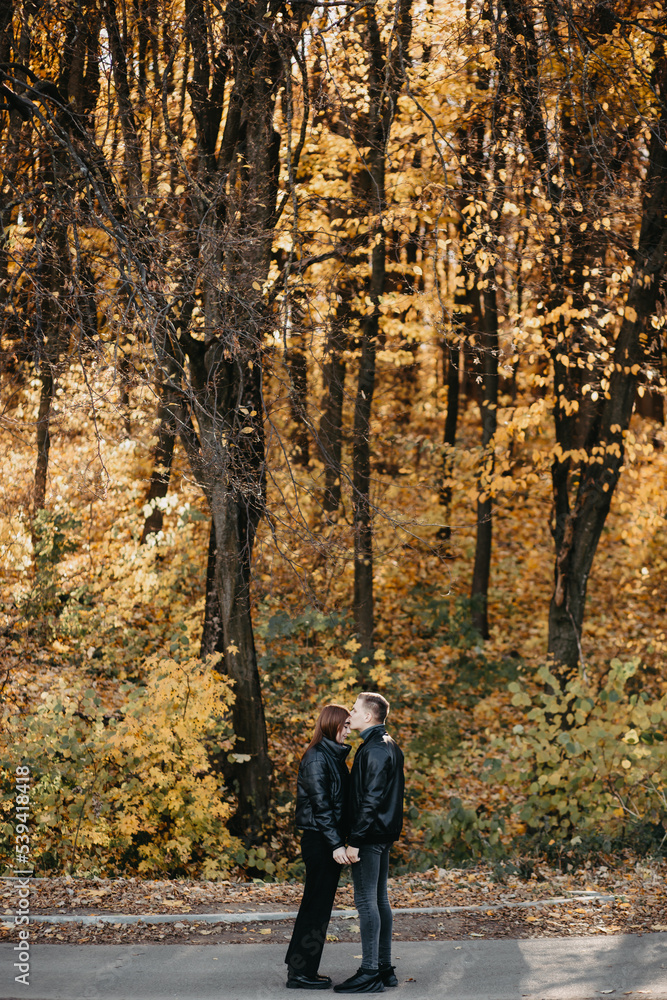 Lovely couple posing in autumn forest, lovers walking in park. lovestory in forest Lovely couple posing in autumn forest, lovers walking in park. lovestory in forest