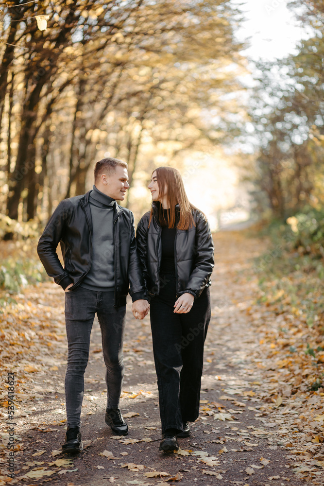 Lovely couple posing in autumn forest, lovers walking in park. lovestory in forest Lovely couple posing in autumn forest, lovers walking in park. lovestory in forest