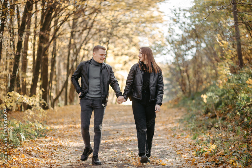 Lovely couple posing in autumn forest, lovers walking in park. lovestory in forest Lovely couple posing in autumn forest, lovers walking in park. lovestory in forest