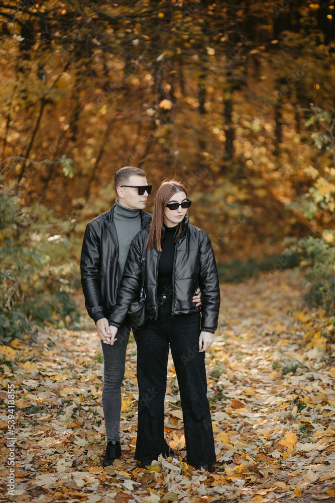 Lovely couple posing in autumn forest, lovers walking in park. lovestory in forest Lovely couple posing in autumn forest, lovers walking in park. lovestory in forest