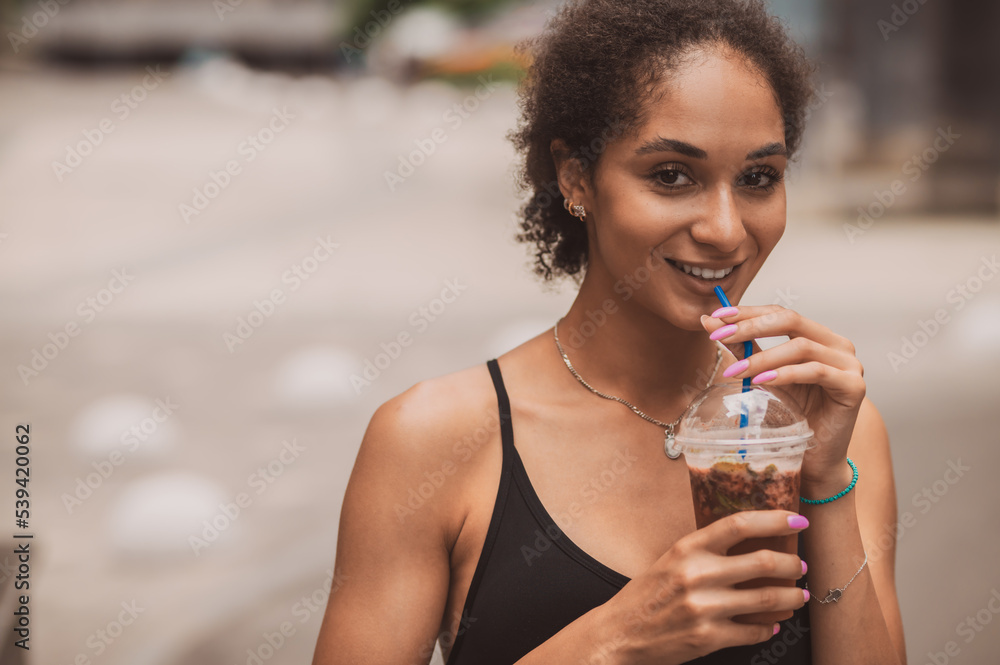 Pretty young sportive girl with a cup of coffee