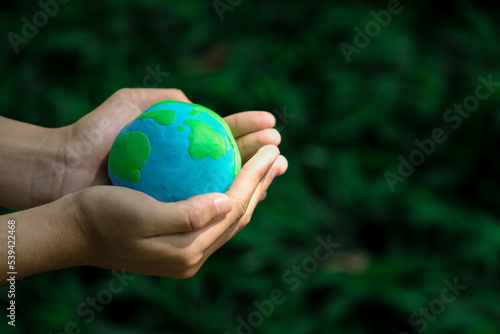 Love world and earth day concept. Young woman holding the earth in hand for ecology care and environment sustainable..