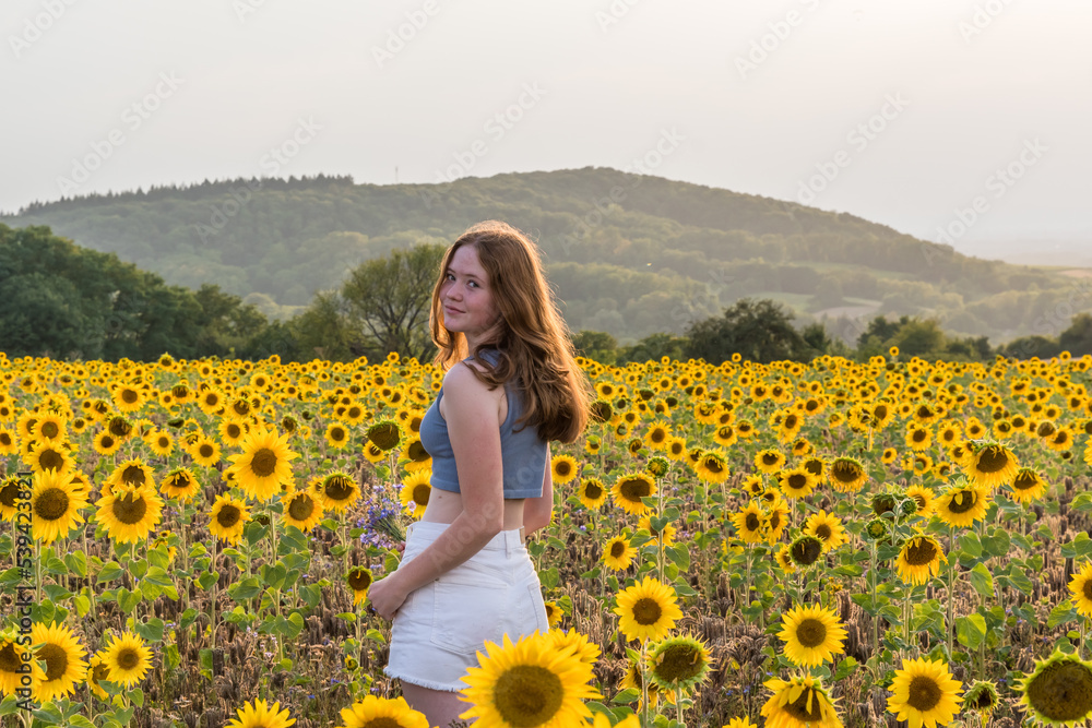 Teenage girl on a sunny summer afternoon in a sunflower field, copy space Teenage girl on a sunny summer afternoon in a sunflower field, copy space