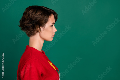 Photo of shiny adorable girl dressed ugly print pullover looking empty space isolated green color background