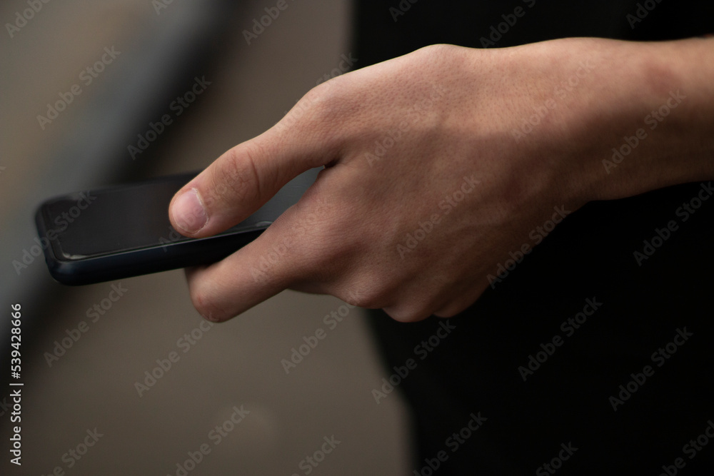 Phone in guys hand. Hand holds smartphone. Smartphone navigation details.