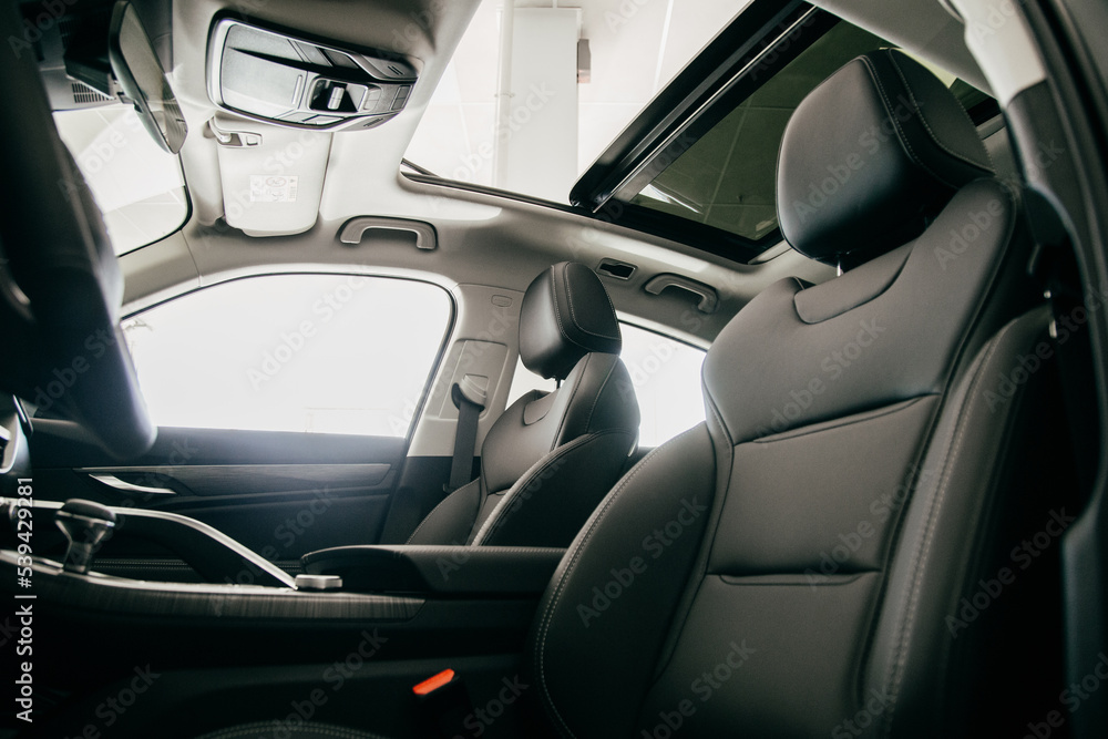 Luxury car inside. Interior of prestige modern car. Black perforated leather seats
