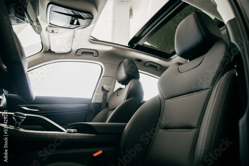 Luxury car inside. Interior of prestige modern car. Black perforated leather seats