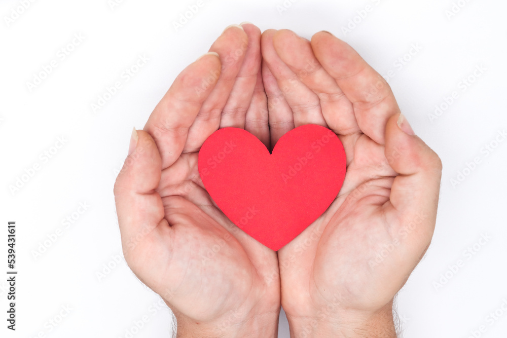 hands holding a paper heart on a white background as a concept of cardiovascular health, heart problems, heart attacks, love, feelings,