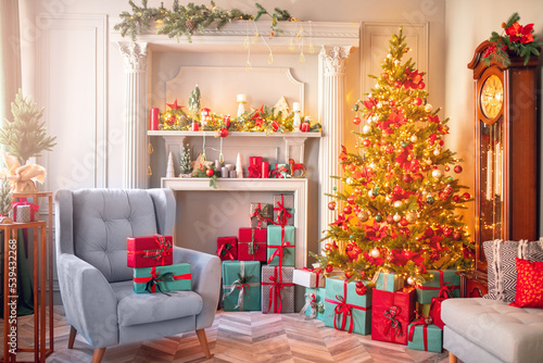 Happy new year interior christmas. Red Decorated glowing tree, armchair with gifts box, fireplace with candles