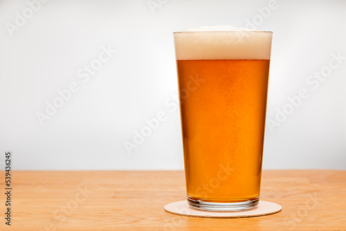Canvas Print Full shaker pint glass of ale or beer on a table