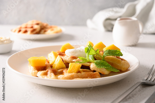 Popular croffles with maple syrup and whipped cream for delicious breakfast. Croissant as waffle.