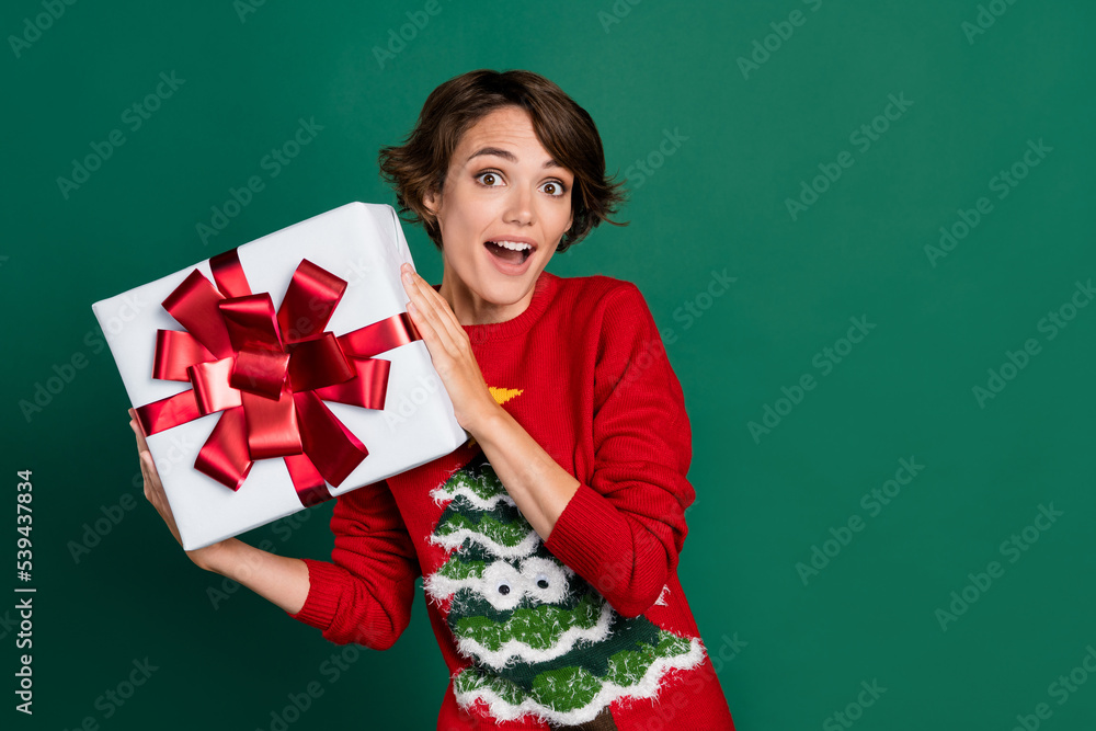 Photo of dreamy excited girl dressed ugly print pullover holding bow present package empty space isolated green color background Photo of dreamy excited girl dressed ugly print pullover holding bow present package empty space isolated green color background