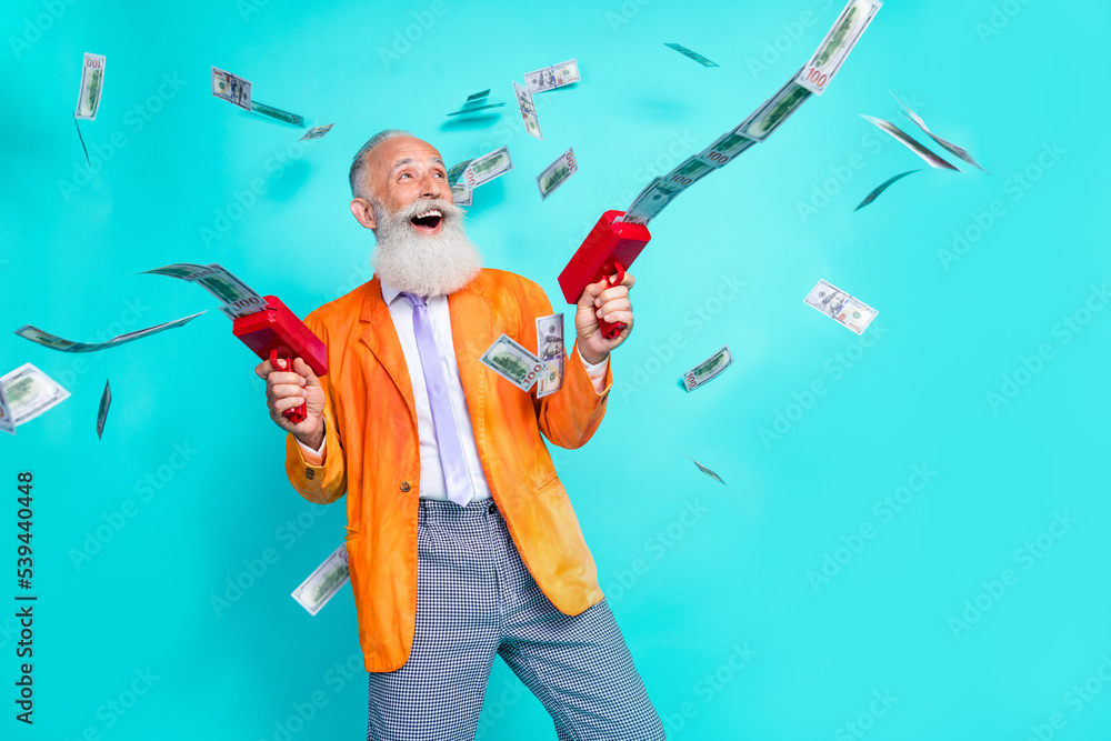 Photo of excited grandfather hold money gun thrown banknotes isolated on teal color background - obrazy, fototapety, plakaty 
