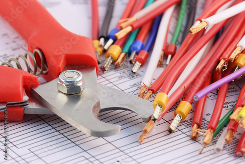 Tools for electrical installation and copper wires in colored insulation on the electrical diagram.Soft focus.