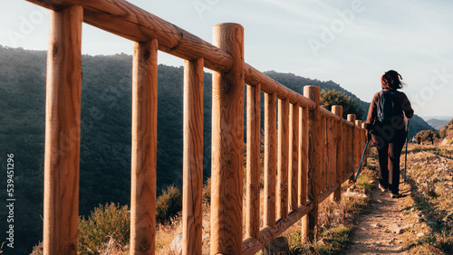 Hiker walking at dawn in a road