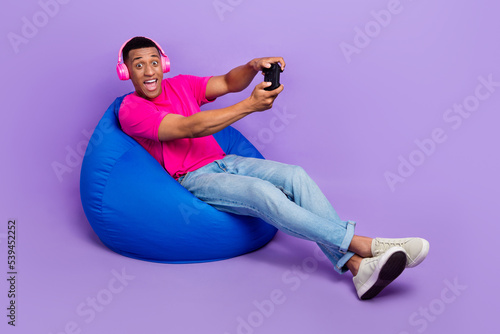 Photo of positive astonished man stylish outfit sit comfort chair have fun enjoy free time empty space isolated on purple color background