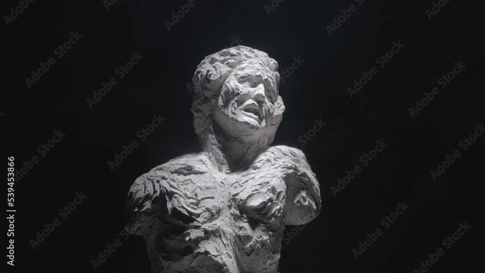 A white statue of a man. A close-up shot on a black background. A white statue of a man. A close-up shot on a black background.