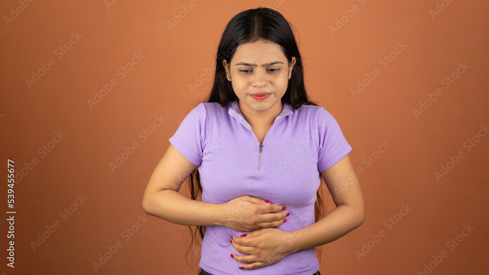 Obraz premium Woman suffering from stomach ache and nausea on color background