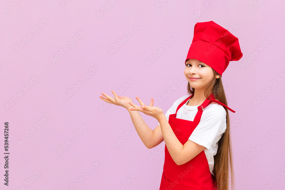The child in the cook's costume stretched out her hands to the side and smiles, children like to cook food themselves, baby food, The child in the cook's costume stretched out her hands to the side and smiles, children like to cook food themselves, baby food,