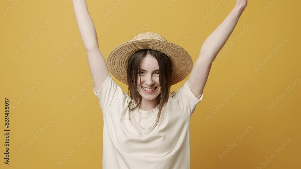 Casul Woman Smiling and she sit happy, jumps up and joy on Yellow Background in Slow Motion. emotion winner. Excitement and a fulfilled wish concept. Lucky Girl happy with hat and white T-shirt. Casul Woman Smiling and she sit happy, jumps up and joy on Yellow Background in Slow Motion. emotion winner. Excitement and a fulfilled wish concept. Lucky Girl happy with hat and white T-shirt.
