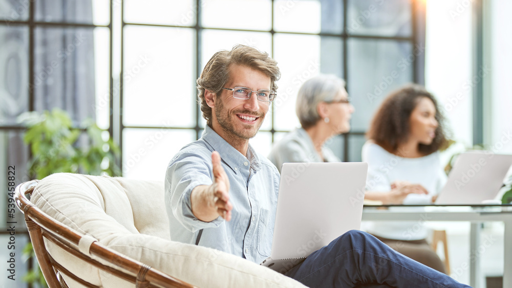 business man with a laptop holding out his hand for a handshake. business man with a laptop holding out his hand for a handshake.