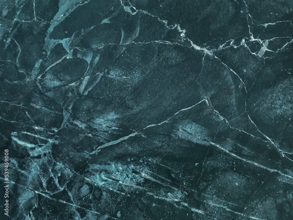 Texture of dark emerald cracked marble with lines pattern, macro background. Navy blue stone backdrop