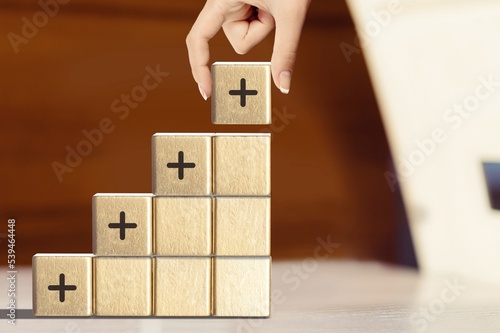 Positive plus icon sign on the wooden cubes