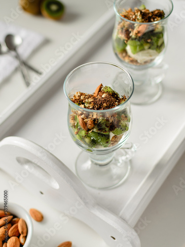 Healthy dessert with muesli and fruits on white background. Healthy breakfast. Granola, nuts and kiwi