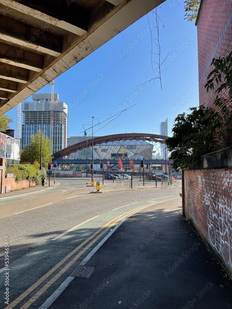City street with modern buildings in the distance and the Ordsall Chord bridge. Taken in Manchester England. 