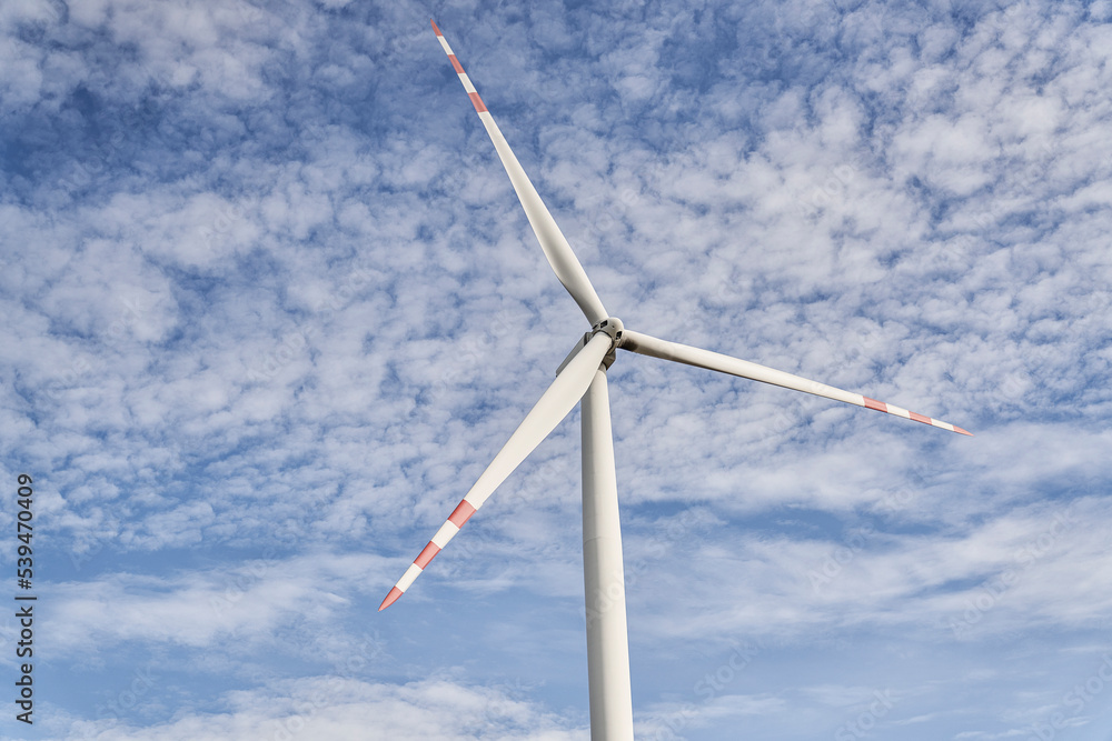 Low angle of wind turbine on blue sky Low angle of wind turbine on blue sky
