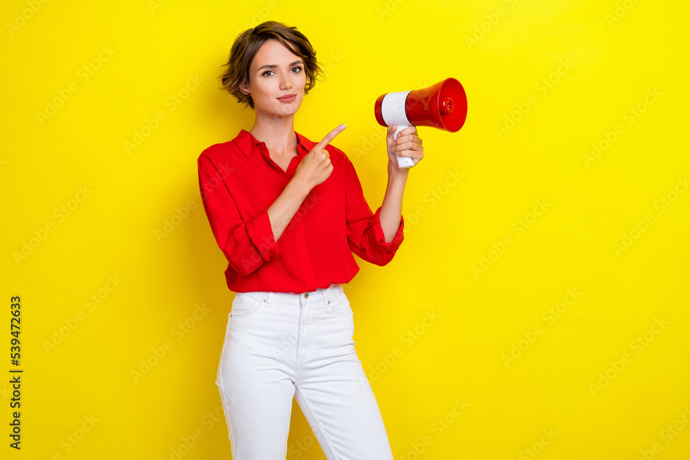 Photo of gorgeous lovely girl with bob hairstyle wear red shirt hold finger indicating megaphone isolated on yellow color background Photo of gorgeous lovely girl with bob hairstyle wear red shirt hold finger indicating megaphone isolated on yellow color background