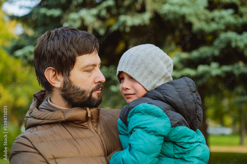 Young caucasian man, dad of little boy pacifying his crying son, hugging him. Father's day concept. Young caucasian man, dad of little boy pacifying his crying son, hugging him. Father's day concept.