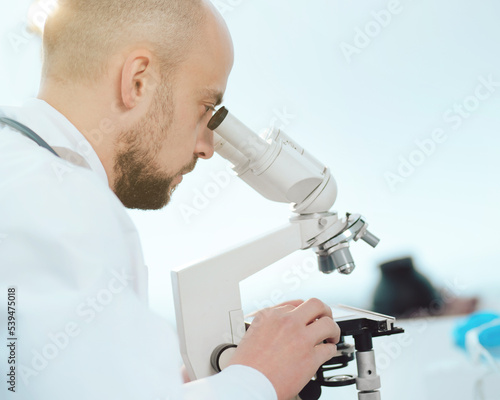 scientist using a microscope in the lab. side view.