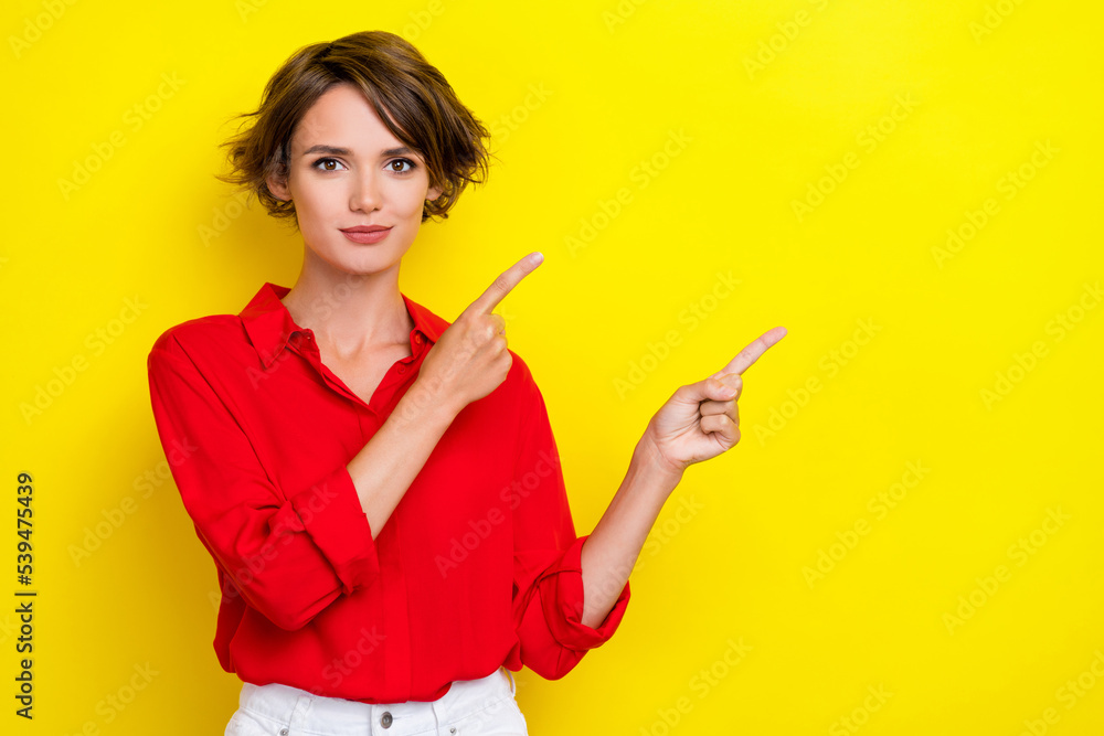 Portrait of nice pretty sweet girl with bob hairdo dressed red shirt fingers indicating empty space isolated on yellow color background Portrait of nice pretty sweet girl with bob hairdo dressed red shirt fingers indicating empty space isolated on yellow color background