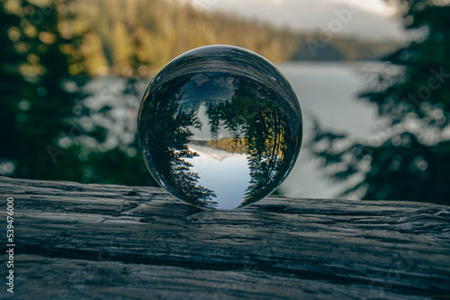 Reflection of Mount Hood, the Lost Lake, and pine trees in a crystal ball.  The image was taken on an autumn day in Oregon, USA.    