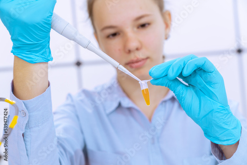 young woman laboratory assistant loads biological sample into microtube  university microbiology laboratory