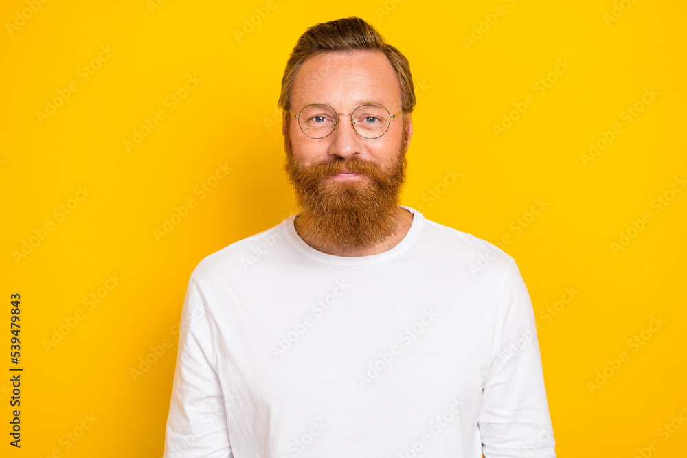 Photo of clever positive person wear eyeglasses look camera isolated on yellow color background Photo of clever positive person wear eyeglasses look camera isolated on yellow color background