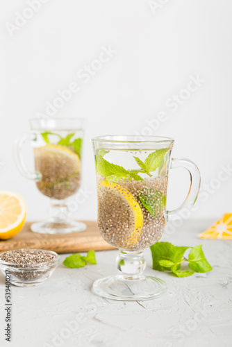 Healthy breakfast or morning with chia seeds lemon and mint on table background, vegetarian food, diet and health concept. Chia pudding with lemon and mint