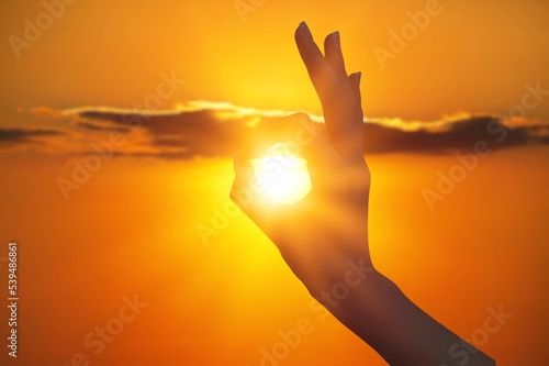Human hands on golden sky background