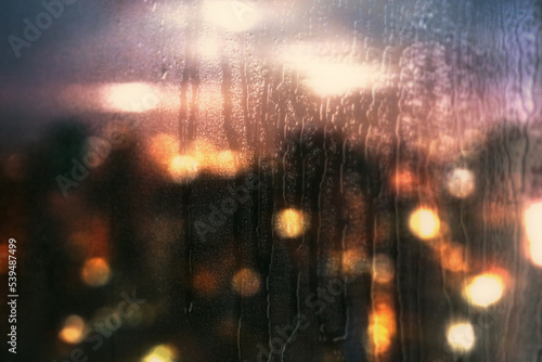 Background of a city lit in the rain through a window