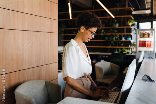 Middle-aged businesswoman working on desktop computer at reception