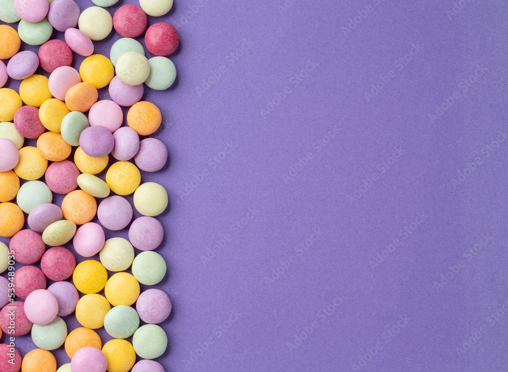 Colorful candies over purple background with copy space Colorful candies over purple background with copy space