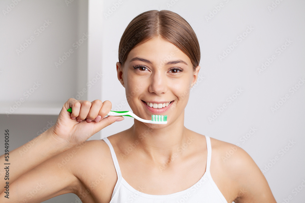 Beautiful young woman brush her teeth in the bathroom Beautiful young woman brush her teeth in the bathroom
